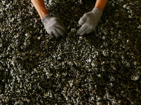 A worker displays nickel ore in a ferronickel smelter owned by state miner Aneka Tambang Tbk at Pomala district, Indonesia.