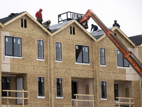 Crews working on shingling a multi-unit housing complex in Regina, Saskatchewan.