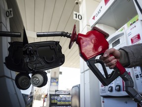 A woman fills up her car with gas in Toronto.