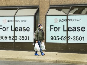 A man walks past office lease signs in downtown Hamilton, Ont., on Thursday, March 18, 2021. Consumer insolvencies for the 12-month period ended Nov. 30, 2022, were up almost ten per cent compared to a year earlier, while business insolvencies for the period were up almost 40 per cent.