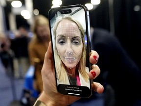 A booth worker demonstrates L'Oreal's smart brow applicator that uses augmented reality to help print eyebrows on the face during CES Unveiled, before the CES tech show, Tuesday, Jan. 3, 2023, in Las Vegas.