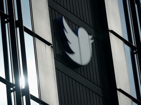 FILE - Un logo Twitter est accroché à l'extérieur des bureaux de la société à San Francisco, le 19 décembre 2022. L'entreprise met aux enchères des souvenirs, du mobilier de bureau de luxe et des équipements de cuisine professionnelle provenant de ses bureaux de San Francisco, où de grands espaces sont désormais vides et où les repas gratuits sont une relique du passé.Même en additionnant le tout, l'argent récolté lors de la vente aux enchères, qui se termine mercredi 18 janvier 2023, ne risque pas de faire une entaille aux obligations financières de Twitter.