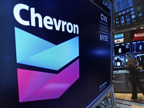 FILE - The logo for Chevron appears above a trading post on the floor of the New York Stock Exchange on Nov. 1, 2021. Shares of Chevron climbed Thursday, Jan. 26, 2023, after the oil company announced that it would repurchase $75 billion of its stock, one of the largest-ever stock buyback plans.