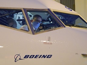 FILE - Capt. Brian Eyre, who was serving as first officer, goes through pre-flight preparations in the flight deck before the first Alaska Airlines passenger flight on a Boeing 737-9 Max airplane, Monday, March 1, 2021, prior to a flight to San Diego from Seattle-Tacoma International Airport in Seattle. Federal officials have named two dozen people to examine safety practices at Boeing, and one of them is a man whose sister died in the crash of a Boeing Max jetliner. The Federal Aviation Administration said the panel includes representatives from NASA, airlines and airline unions.