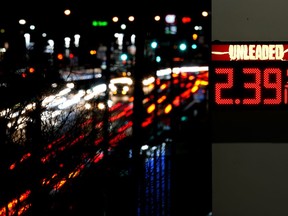 File - Cars pass a gas station sign displaying the price of regular unleaded gasoline Tuesday, Dec. 13, 2022, in Benton, Mo. On Thursday, the Labor Department reports on U.S. consumer prices for December.