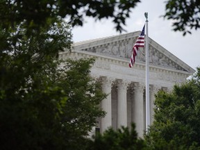 FILE - An American flag waves in front of the U.S. Supreme Court building in Washington, June 27, 2022. Supreme Court arguments are continuing long after a red light tells lawyers to stop. Arguments that usually lasted an hour have stretched beyond two this term so on many days it is well past lunchtime before the court breaks.