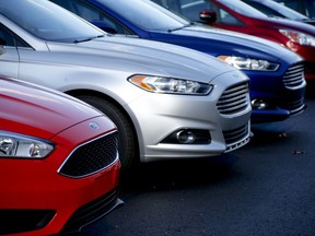 FILE - A row of new Ford Fusions are for sale on the lot at Butler County Ford in Butler, Pa., Nov. 19, 2015. A shortage of computer chips and other parts hobbled the U.S. auto industry in 2022, slowing factories and contributing to an expected 8% decline in sales from the previous year. And although supplies are improving and prices are coming down a little, auto factories aren't likely to get back to full production until next year.