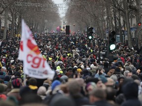 FILE - Protestors march during a demonstration against pension changes, Thursday, Jan. 19, 2023 in Paris. France's national rail operator is recommending that passengers work from home if possible Tuesday Jan. 31, 2023 to spare them from labor strikes over pensions that are expected to cause major transport woes.