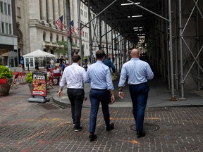 Pedestrians pass in front of the New York Stock Exchange.