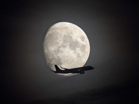 An aircraft is silhouetted against the moon in Frankfurt, Germany, Thursday, Oct. 6, 2022. The number of commercial pilot licences issued in Canada annually has declined by more than 80 per cent since 2019, even as aviation experts warn of an ever-growing labour shortage that threatens to disrupt Canada's airline industry.