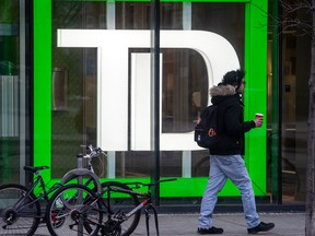 A pedestrian walks past TD Bank signage in Toronto.