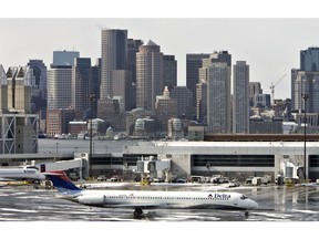 UNITED STATES - FEBRUARY 28: The Boston skyline rises beyond a Delta Air Lines jet as it taxis at Logan International Airport in Boston, Massachusettes, U.S., on Thursday, Feb. 28, 2008. Delta Air Lines Inc., one year removed from bankruptcy, agreed to merge with Northwest Airlines Corp. in a $3.1 billion stock deal that would create the world's largest carrier and may unleash more industry consolidation.