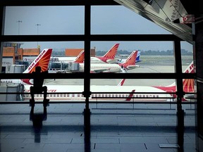 FILE- Air India planes are parked at Indira Gandhi International Airport in New Delhi, India on Aug. 30, 2021. Indian police have arrested an unruly airline passenger following a complaint by a woman aboard an Air India flight from New York that he urinated on her in business class.