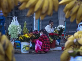 FILE - Woman arrange flowers at a street market in Yangon, Myanmar, on Feb. 2, 2021. World Bank economists say Myanmar's economy grew 3% in 2022 and will likely achieve the same pace of growth in 2023, but still lags far behind where it stood before the army seized power in early 2021.