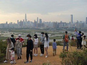 FILE - People visit the border of Hong Kong, with the skyline of China's Shenzhen in the background, in Hong Kong Feb. 13, 2021. Hong Kong will start to reopen its border with mainland China on Sunday, Jan. 8, 2023, allowing tens of thousands of people to travel between both sides each day under a quarantine-free arrangement, the city's leader said Thursday, Jan. 5.