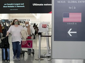 People travel to the United States of America at Pearson International Airport in Toronto, Friday, Dec. 3, 2021. Air Canada warned travellers to check their flights before heading to the airport as troubles caused by a key computer outage at the U.S. Federal Aviation Administration caused delays.