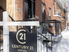 Signs advertising houses for sale are shown in Montreal, Friday, March 4, 2022. The Quebec Professional Association of Real Estate Brokers says last month's home sales fell 39 per cent from a year earlier to a level not seen in December since 2014.