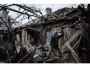 Oleksandr Pykhtin (L), 73, tries to open a refrigerator at his house destroyed by a rocket last night as the sounds of gunshots and artillery continue in the distance in Chasiv Yar on January 28, 2023. Photographer: Yasuyoshi Chiba/AFP/Getty Images