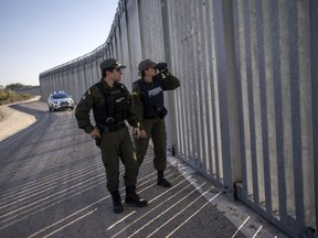 FILE - Police border guards patrol along a border wall near the town of Feres, along the Evros River which forms the frontier between Greece and Turkey on Sunday, Oct. 30, 2022. Greece prevented some 260,000 migrants from entering illegally in 2022 and arrested 1,500 traffickers, Greece's minister in charge of the security told ambassadors from other European Union countries plus Switzerland and the United Kingdom Saturday, Jan. 21, 2023, as he guided them to a still expanding border wall in the country's northeast.