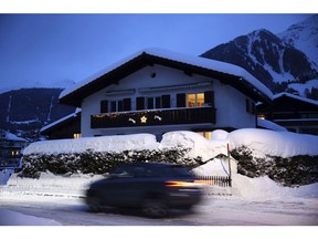 A car pasts a property illuminated at dusk in Klosters, on Saturday, Dec. 30, 2017. Photographer: Stefan Wermuth/Bloomberg