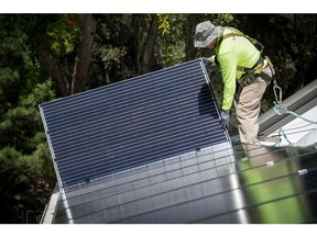 A PetersenDean Inc. employee installs a solar panel on a home in Lafayette, California, U.S., on Tuesday, May 15, 2018. California became the first state in the U.S. to require solar panels on almost all new homes. Most new units built after Jan. 1, 2020, will be required to include solar systems as part of the standards adopted by the California Energy Commission. Photographer: David Paul Morris/Bloomberg
