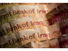 Iraqi dinar banknotes sit in this arranged photograph in London, U.K., on Monday, April 15, 2019. Iraq's real GDP to accelerate slightly to average about 2 percent due to rising oil production, compared with about 1 percent in 2017, S&P said in statement.