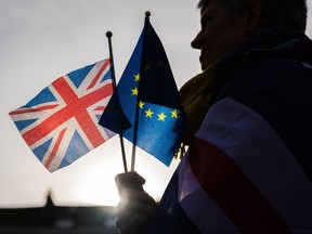 A Pro Europa supporter holds European Union (EU) and a British Union flags during a gathering by the cross party Pro-EU anti-Brexit group in Brussels, Belgium, on Thursday, Jan. 30, 2020. The European Parliament approved Prime Minister Boris Johnson's Brexit deal, clearing the way for the U.K. to leave the EU on Jan. 31 with an agreement that, for the time being, will avoid a chaotic rupture. Photographer: Geert Vanden Wijngaert/Bloomberg