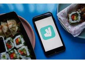 The Deliveroo logo is displayed on a smartphone between dishes of delivered sushi in this arranged photograph in London, U.K., on Tuesday, Aug. 11, 2020. Just Eat Takeaway.com NV are due to report earnings on Aug. 12.