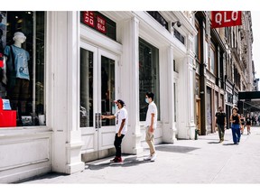 Shoppers wearing protective masks enter a Uniqlo Co. store in the Soho neighborhood of New York, U.S., on Thursday, Aug. 6, 2020. The Bloomberg Consumer Comfort index rose last week to 44.9 from 44.3 a week earlier. Photographer: Nina Westervelt/Bloomberg