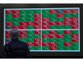 An electronic stock board outside a securities firm in Tokyo, Japan, on Monday, Nov. 21, 2022. The world's central banks must keep raising interest rates to fight soaring and pervasive inflation, even as the global economy sinks into a significant slowdown, the OECD said. Photographer: SeongJoon Cho/Bloomberg