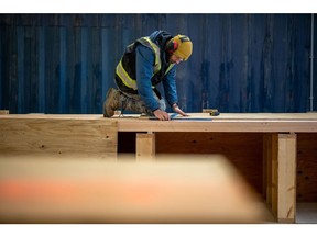A worker measures mass timber ceiling panels in Bamberton, British Columbia. Photographer: James MacDonald/Bloomberg