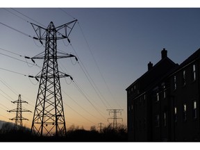 Electricity transmission pylons next to a block of residential apartments in St Neots, UK, on Wednesday, Dec. 14, 2022. UK power prices for Monday jumped to record levels as freezing temperatures are set to cause a surge in demand, just as a drop in wind generation causes a supply crunch.
