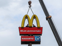 Workers use a crane to dismantle the McDonald's Golden Arches while removing the logo signage from a drive-through restaurant in the town of Kingisepp in the Leningrad region, of Russia, last spring.