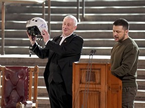 Speaker of the House of Commons, Sir Lindsay Hoyle, left, holds the helmet of one of the most successful Ukrainian pilots, inscribed with the words "We have freedom, give us wings to protect it", which was presented to him by Ukrainian President Volodymyr Zelenskyy as he addressed parliamentarians in Westminster Hall, London,, during his first visit to the UK since the Russian invasion of Ukraine, Wednesday Feb. 8, 2023.