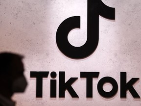 FILE - A visitor passes the TikTok exhibition stands at the Gamescom computer gaming fair in Cologne, Germany, Thursday, Aug. 25, 2022. The European Union's executive arm said Thursday, Feb. 23, 2023 it has temporarily banned TikTok from phones used by employees as a cybersecurity measure, reflecting growing worries from authorities over the Chinese-owned video sharing app.