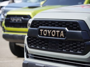 FILE - The company logo highlights the grille of a 2021 Tacoma pickup truck on display in the Toyota exhibit at the Denver auto show Friday, Sept. 17, 2021, at Elitch's Gardens in downtown Denver. Toyota reported a 64% drop in fiscal third quarter profit Thursday, Feb. 9, 2023, as a global shortage of chips and soaring raw material costs battering the auto industry hit Japan's top automaker.