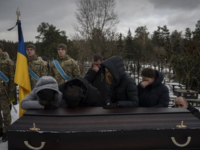 Relatives stand by the coffin of Eduard Strauss, a Ukrainian serviceman who died in combat on Jan. 17 in Bakhmut, during his funeral in Irpin, Ukraine, Monday, Feb. 6, 2023.