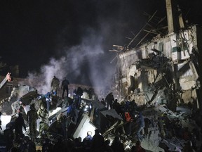 Emergency workers and local residents clear the rubble after a Russian rocket hit an apartment building in Kramatorsk, Ukraine, on Thursday, Feb. 2, 2023.