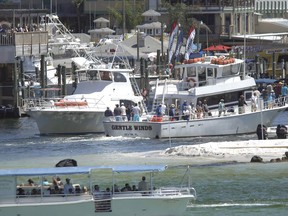 FILE - In a Friday April 6, 2012 photo, charter fishing boats go in and out of Destin Harbor in Destin, Fla. An appeals court has struck down a federal fisheries management rule requiring operators of privately owned charter boats to equip their vessels with tracking devices, a victory for a group of Louisiana and Florida charter operators who challenged the rule in a 2020 lawsuit.