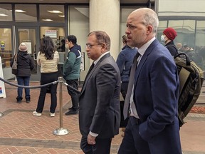 Former Theranos executive Ramesh "Sunny" Balwani, center, walkes to federal court with his attorney Mark Davies, Friday, Feb. 17, 2023 in San Jose, Calif. Balwani returned to federal court Friday in a last-ditch attempt to stay out of prison while he appeals a jury's verdict convicting him of deceiving investors and patients in a blood-testing hoax that he orchestrated with his former boss and lover, Elizabeth Holmes.