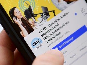 A person navigates to the on-line social-media pages of the Canadian Radio-television and Telecommunications Commission (CRTC) on a cell phone in Ottawa on May 17, 2021. Canada's telecommunications regulator is directing all service providers to notify it within two hours when they become aware of an outage to their networks.