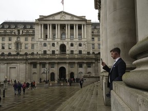 FILE - A man walks in front of the Bank of England, at the financial district in London, on Nov. 3, 2022. The Bank of England is expected to raise interest rates by as much as half a percentage point Thursday, Feb. 2, 2023 as it seeks to tame the double-digit inflation fuelling a cost-of-living crisis, public-sector strikes and fears of recession.