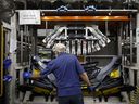 Un employé assemble un pare-chocs à l'usine de fabrication de pièces automobiles de Magna International Inc. Polycon Industries à Guelph, en Ontario.