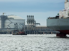 The Amazon Brilliance oil tanker, right, sails past a storage tank, left, at the Cheniere Energy Inc. liquefied natural gas terminal in Sabine Pass, Louisiana, U.S., on Thursday.