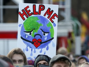 People carry a sign as they attend a protest during the UN Climate Change Conference (COP26) in Glasgow, Scotland, Britain, 2021.