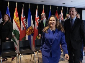 Chrystia Freeland, centre, Canada's Deputy Prime Minister and Minister of Finance laughs next to Eric Girard, right, Minister of Finance of Quebec after a group photograph during the Finance Ministers' Meeting in Toronto, on Friday, February 3, 2023.