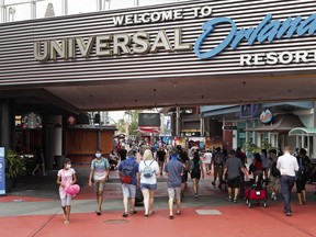 FILE - Visitors arrive at Universal Studios, on June 3, 2020, in Orlando, Fla. Universal Orlando Resort plans to raise its starting minimum wage by $2 to $17 an hour, according to a letter to workers Tuesday, Feb. 14, 2023, becoming the local theme park wage leader in central Florida, just as its crosstown rival, Walt Disney World, is in contract talks with service worker unions who are pushing to increase the starting hourly wage from $15 to $18.