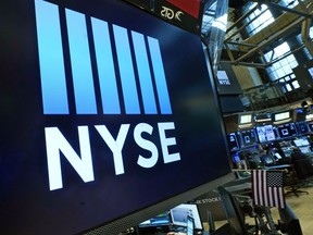 FILE - Logos the New York Stock Exchange adorn trading posts, on the floor, Wednesday, March 16, 2022.