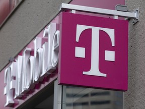 FILE - The T-Mobile logo is seen on a storefront, on Oct. 14, 2022, in Boston. Customers of the wireless provider reported widespread service outages in the U.S. late Monday, Feb. 13, 2023, according to websites tracking service interruptions.