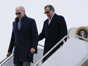 President Joe Biden and his son, Hunter Biden, step off Air Force One, Saturday, Feb. 4, 2023, at Hancock Field Air National Guard Base in Syracuse, N.Y. The Bidens are in Syracuse to visit with family members following the passing of Michael Hunter, the brother of the president's first wife, Neilia Hunter Biden.